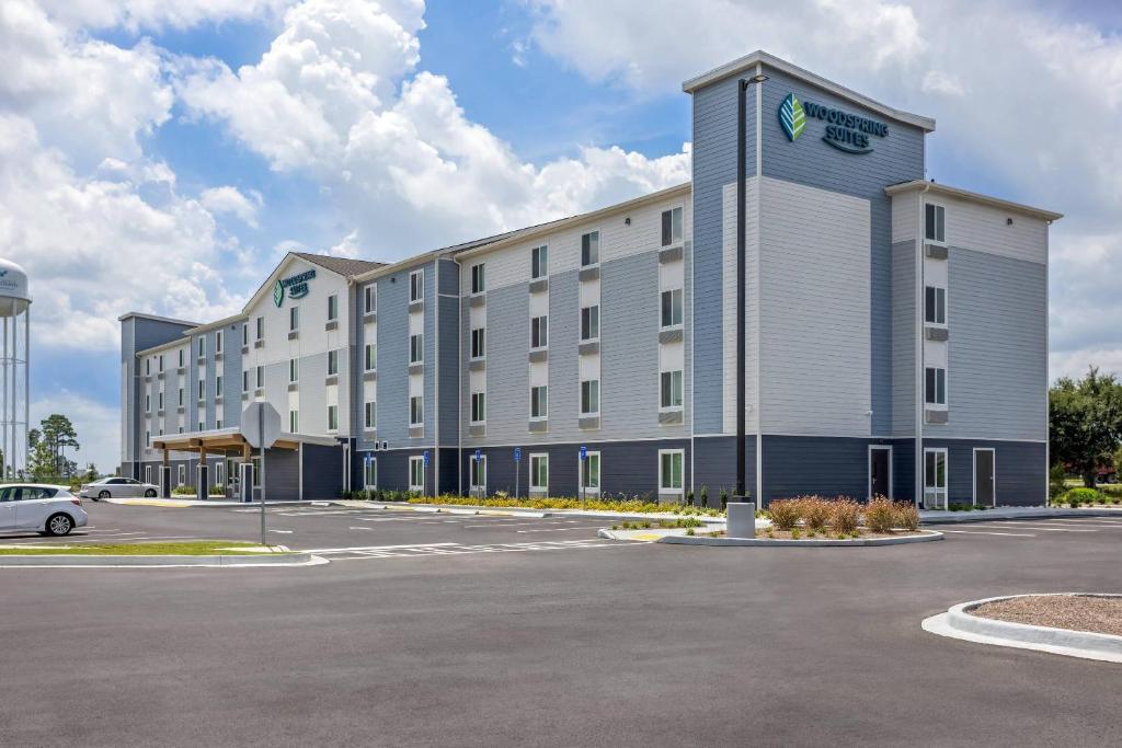 a hotel with a parking lot in front of it at WoodSpring Suites Savannah West - Ellabell Metaplant in Ellabell