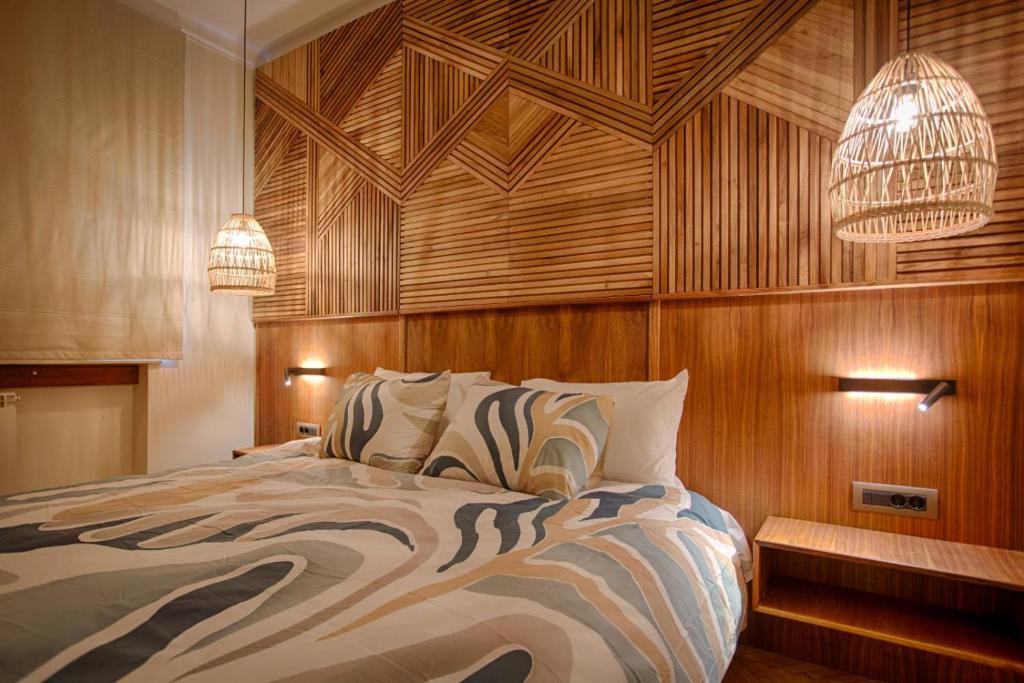 Luxury and stylish apartment in the heart of the city في صوفيا: غرفة نوم بسرير كبير مع جدران وأضواء خشبية