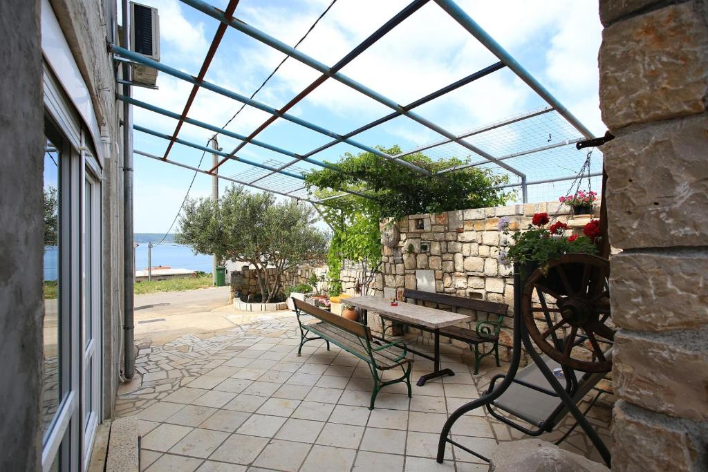 een terras met een bank en een tafel met een glazen dak bij Apartment Marta in Maslenica