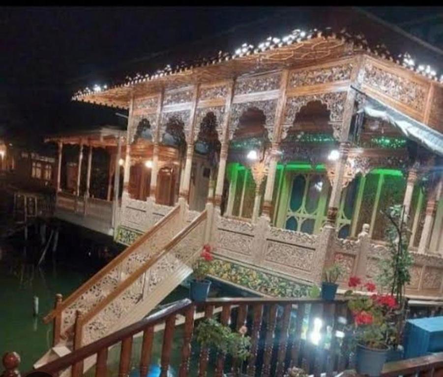 un edificio sobre el agua con luces verdes en Houseboat New Golden Fleece, en Srinagar