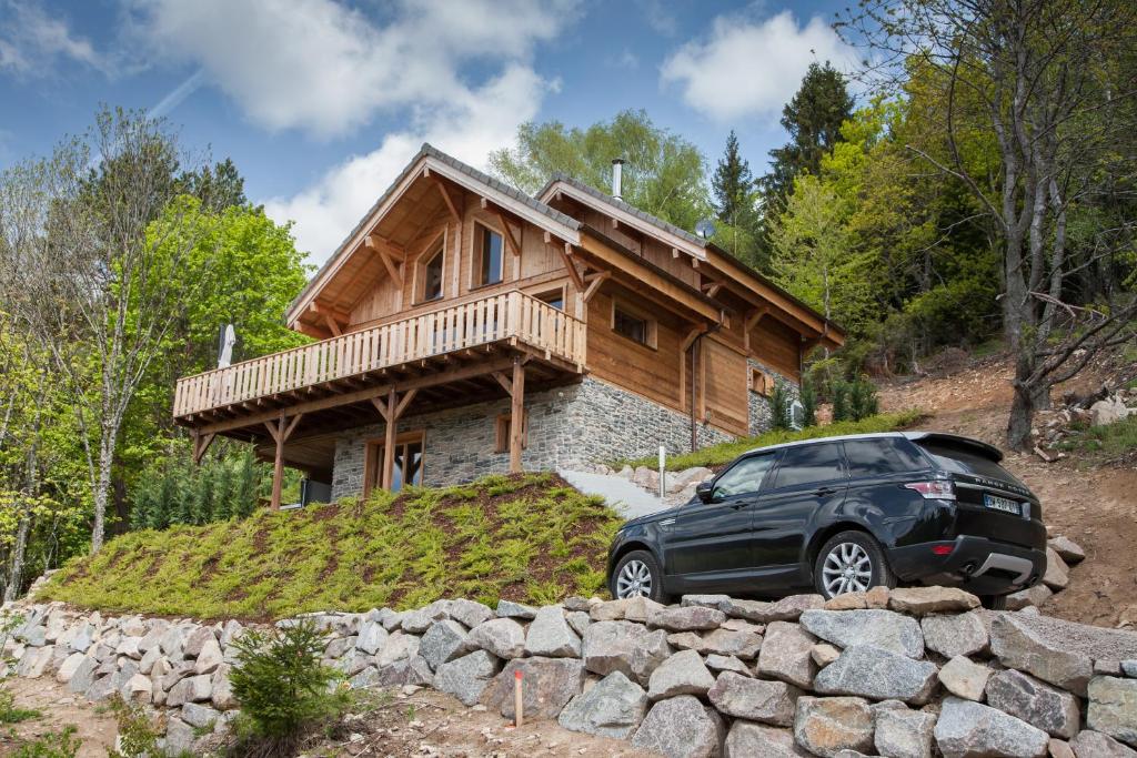 un coche aparcado frente a una casa de madera en Les chalets perchés en Muhlbach-sur-Munster