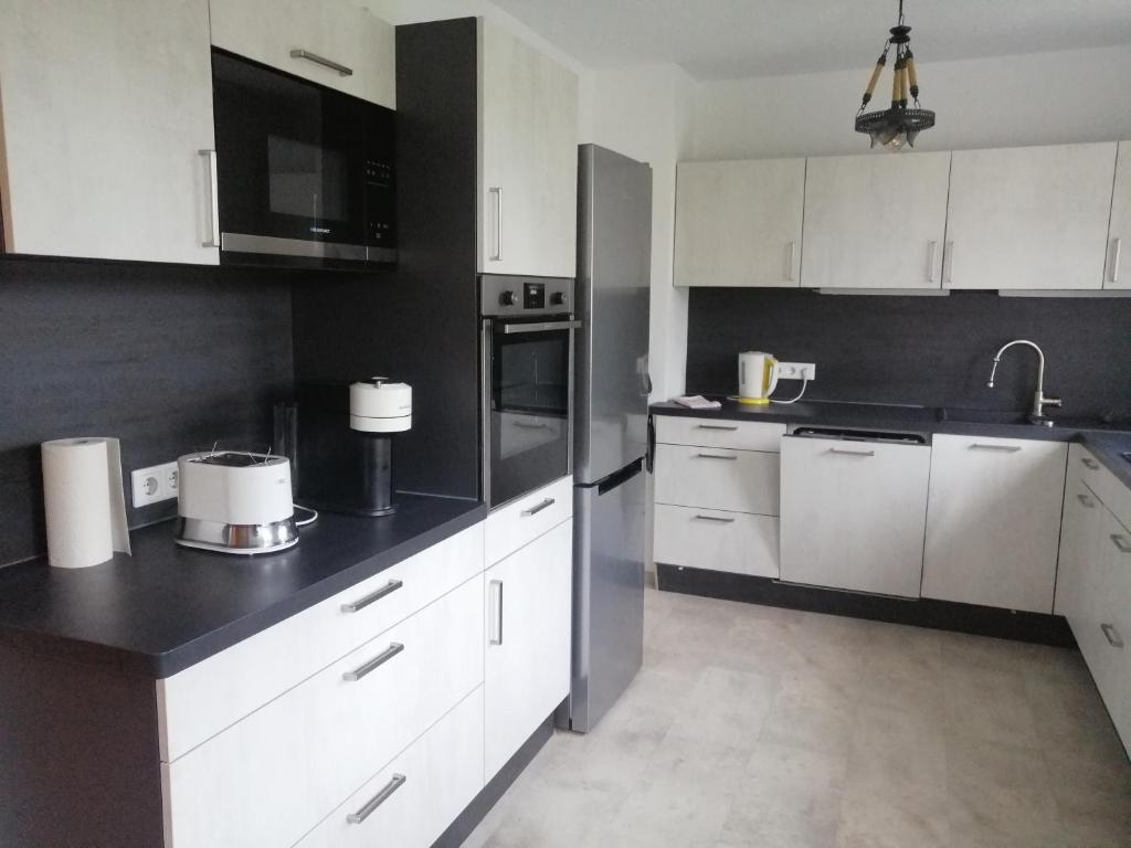 a kitchen with white cabinets and black counter tops at Allgäu Space in Marktoberdorf