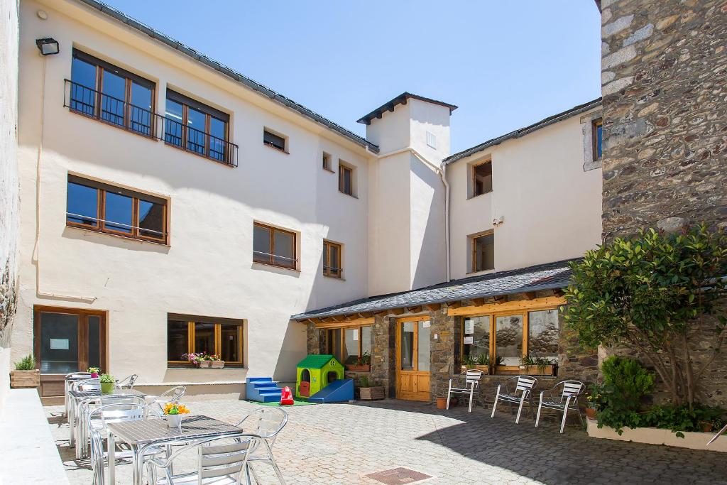 un patio con mesas y sillas en un edificio en Alberg Anna Maria Janer, en Llivia