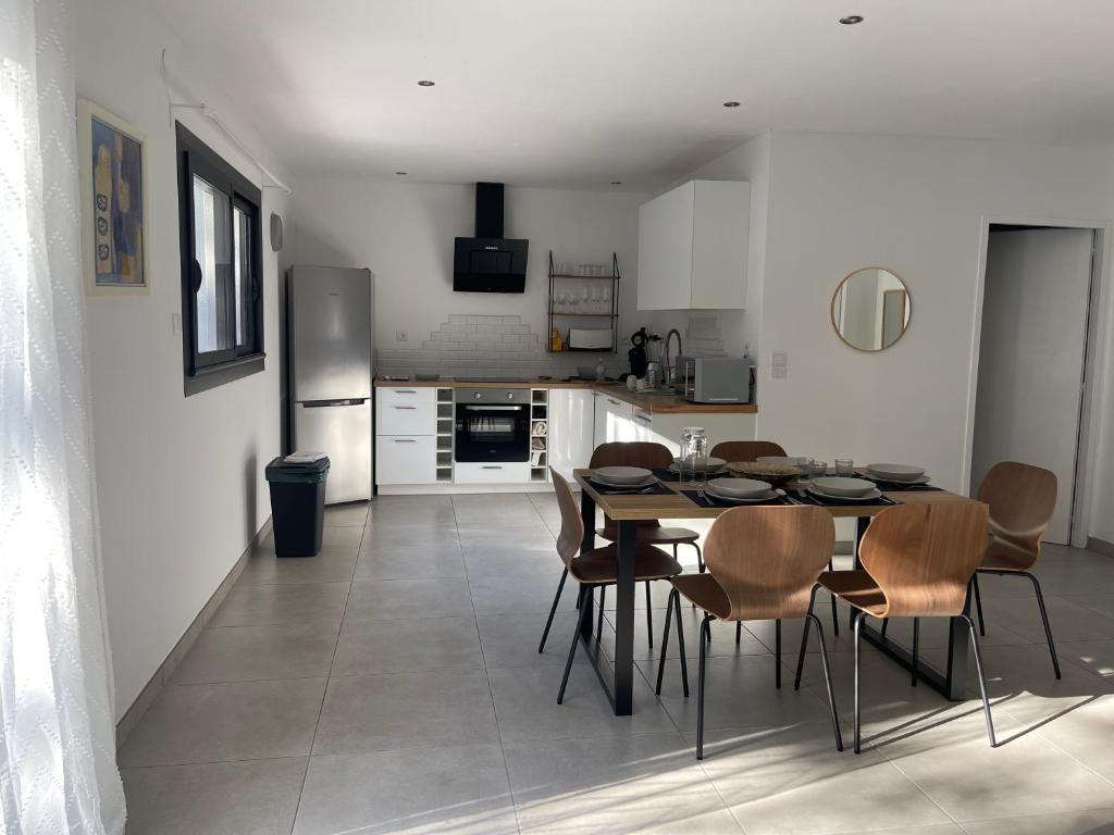 a kitchen and dining room with a table and chairs at Maison Romarin in Le Boulou
