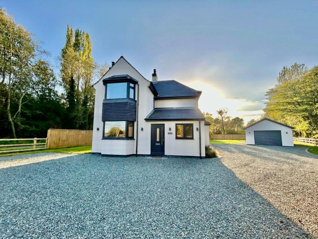 a white house on a gravel driveway at Marzion House with Hot Tub in Tattershall Thorpe