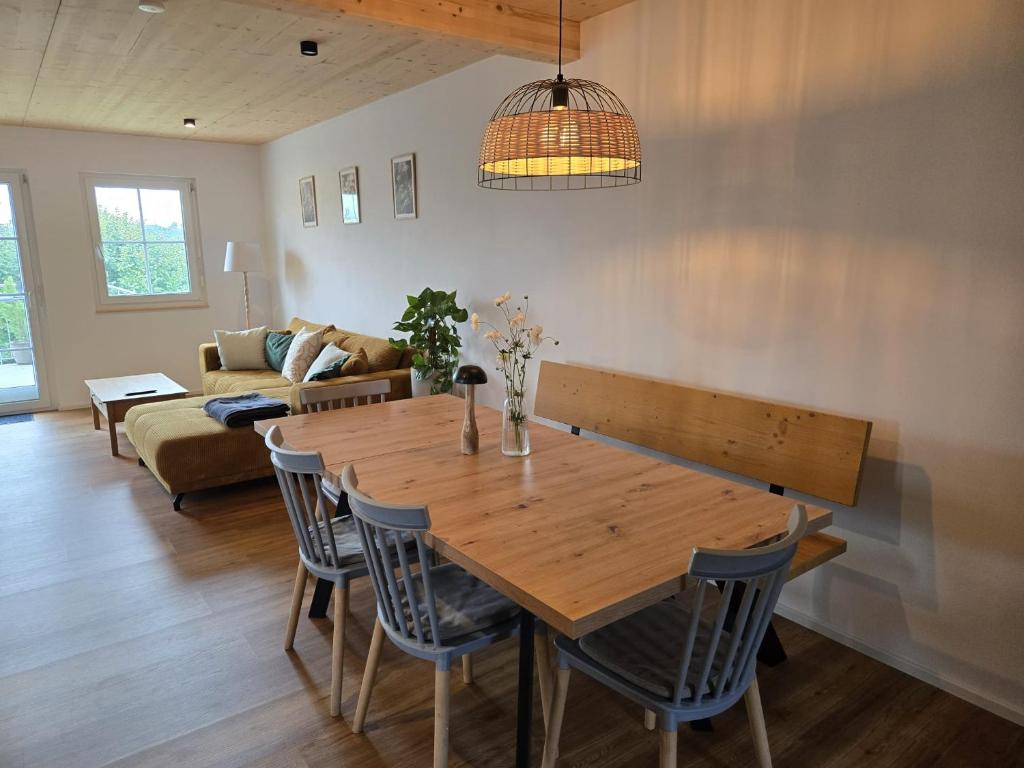 une table et des chaises en bois dans un salon dans l'établissement FeWo2 großräumige FeWo in Riegel am Kaiserstuhl über 2 Etagen, Galerie, Balkon, à Riegel am Kaiserstuhl
