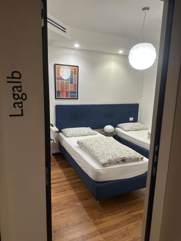 two beds in a bedroom with a blue headboard at Tirano stazioni flow rooms in Tirano