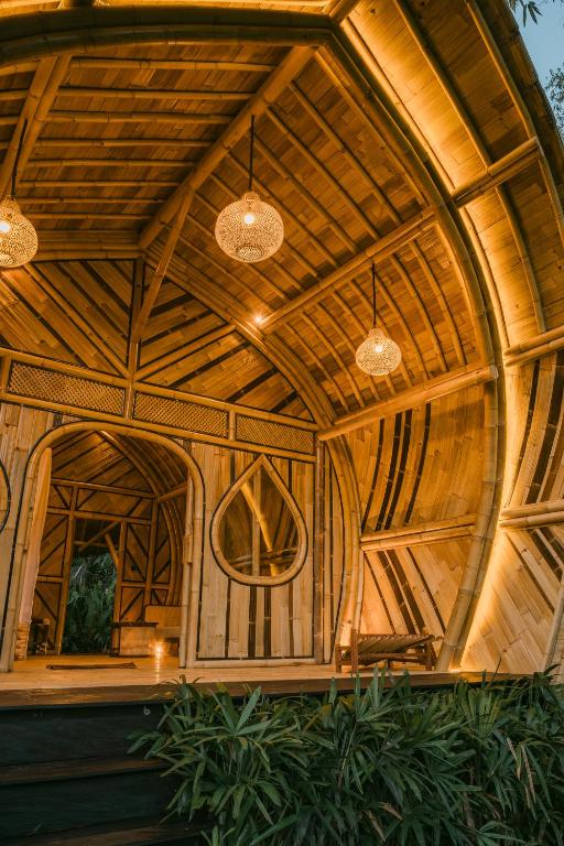 a large wooden building with two pendant lights at Asvara Eco Bali Bamboo House in Sidemen