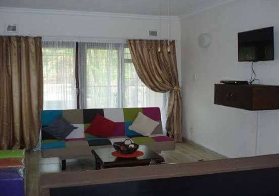 a living room with a couch with colorful pillows at Oswald Ramgate Beach in Margate