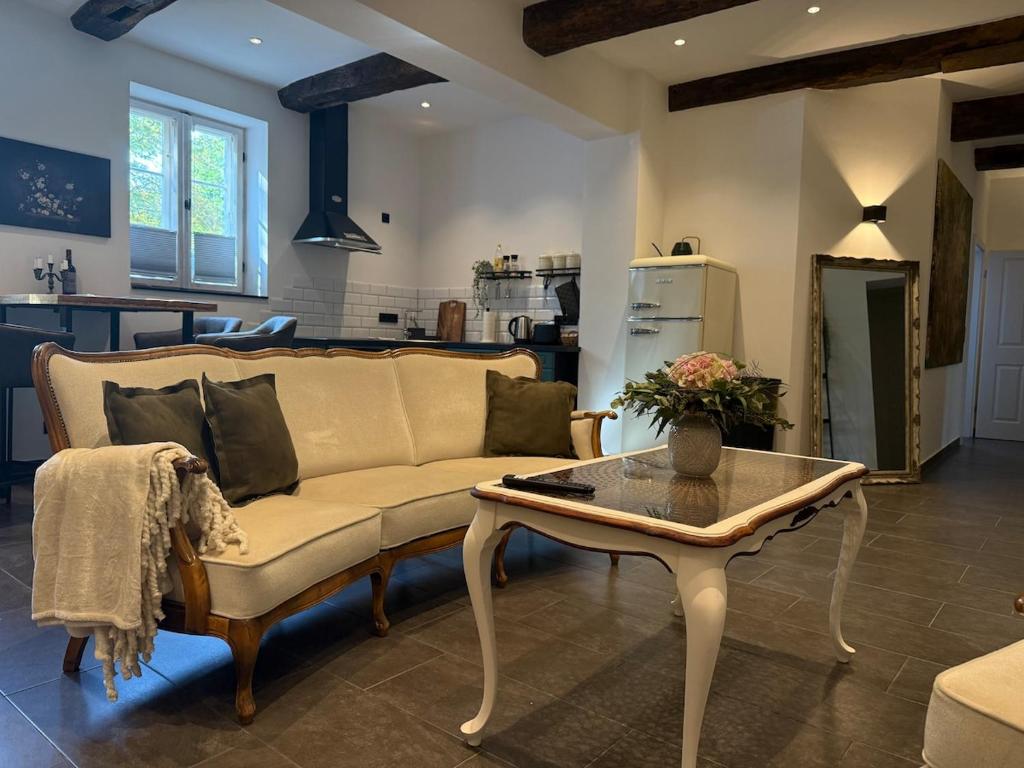 ein Wohnzimmer mit Sofa und Tisch in der Unterkunft Müllerstube im historischen Müllerhaus in Lübeck