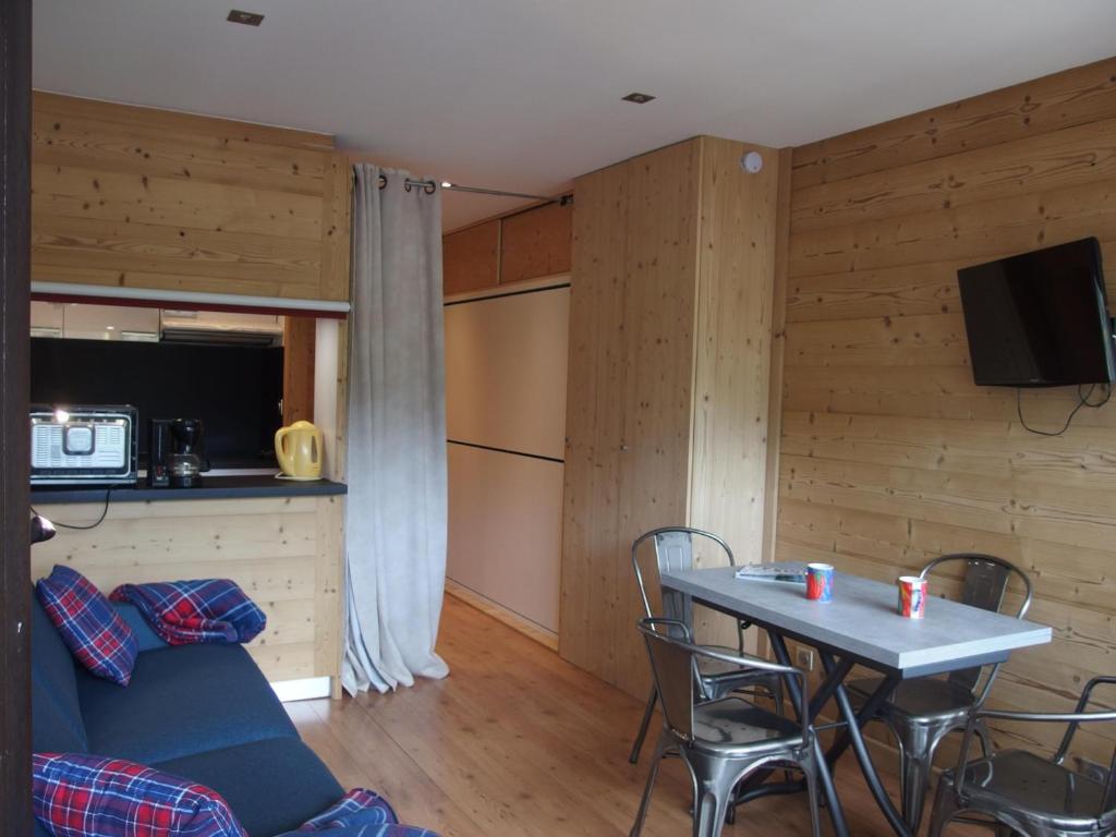 ein Wohnzimmer mit einem Tisch und einer Küche in der Unterkunft Wapiti 26 in La Clusaz
