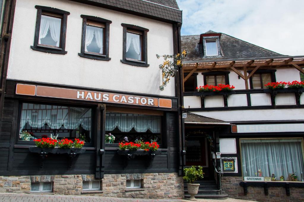 ein Gebäude mit Blumen in den Fenstern eines Ladens in der Unterkunft Gasthaus Castor in Klotten