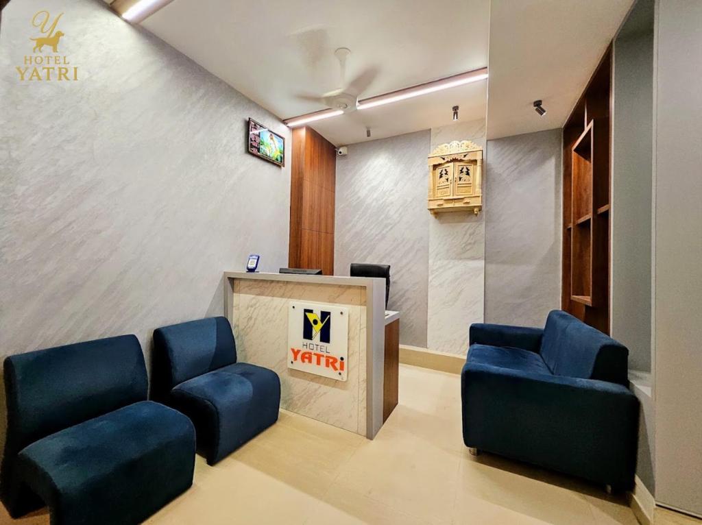a waiting room with two blue chairs and a podium at Hotel Yatri in Gandhinagar