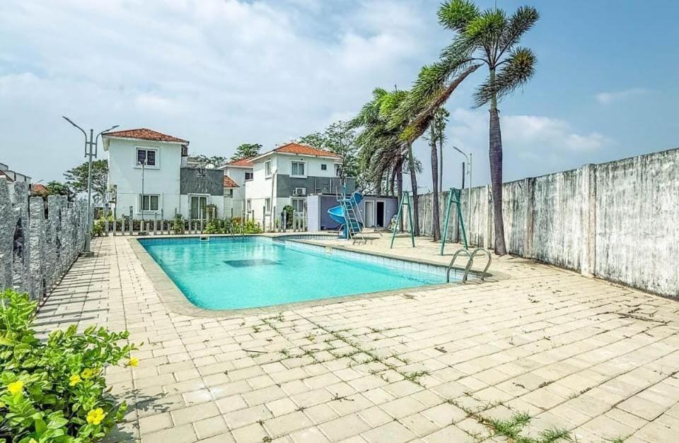 a swimming pool in the backyard of a house at Lavin's villa in Tirupporūr