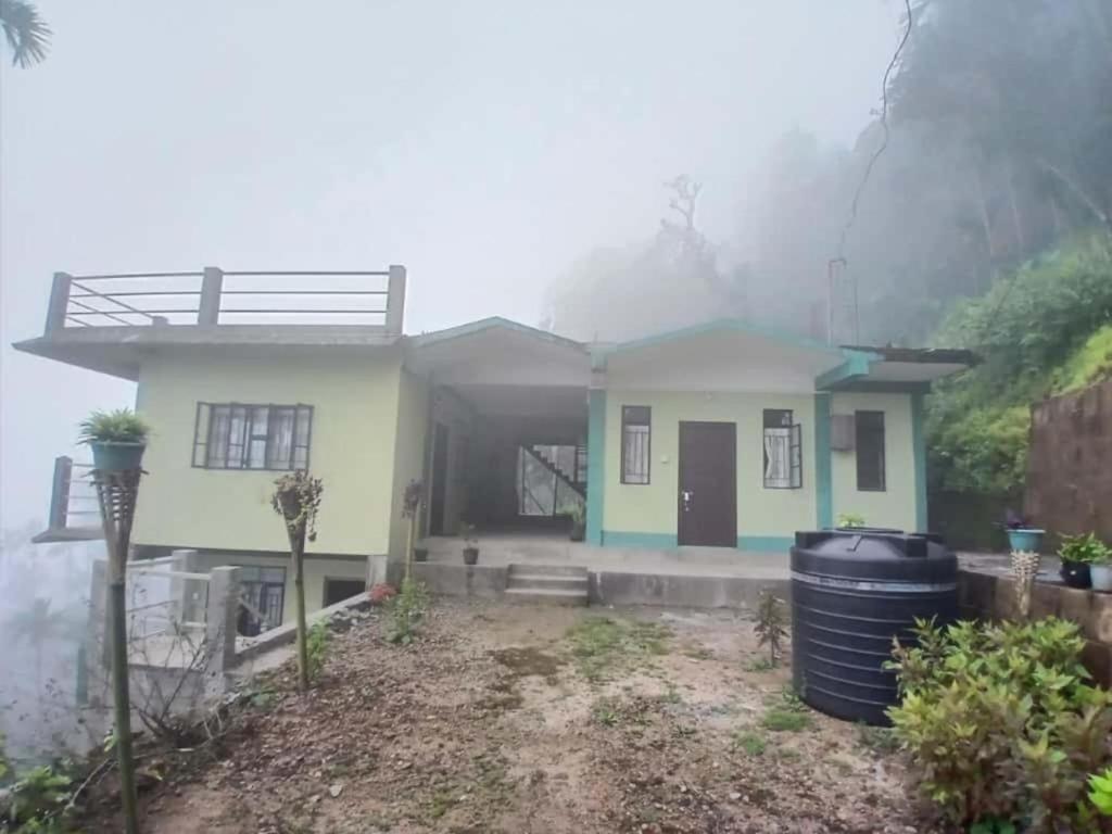 a house with smoke coming out of it at Siej Homestay in Cherrapunji