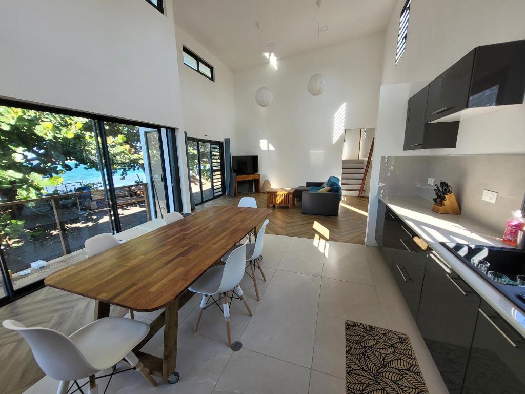 Una cocina y un comedor con mesa y sillas de madera. en Villa Venus, en Mahina