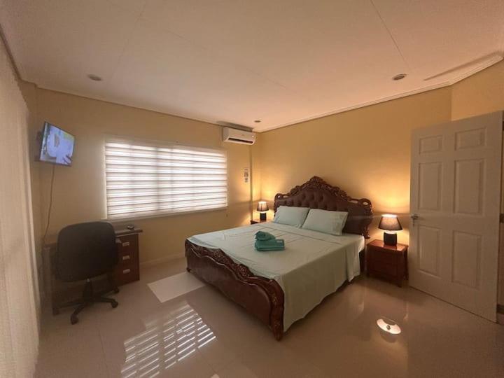 une chambre avec un lit, un bureau et une fenêtre dans l'établissement Pelaez house in the bogo, à Bogo