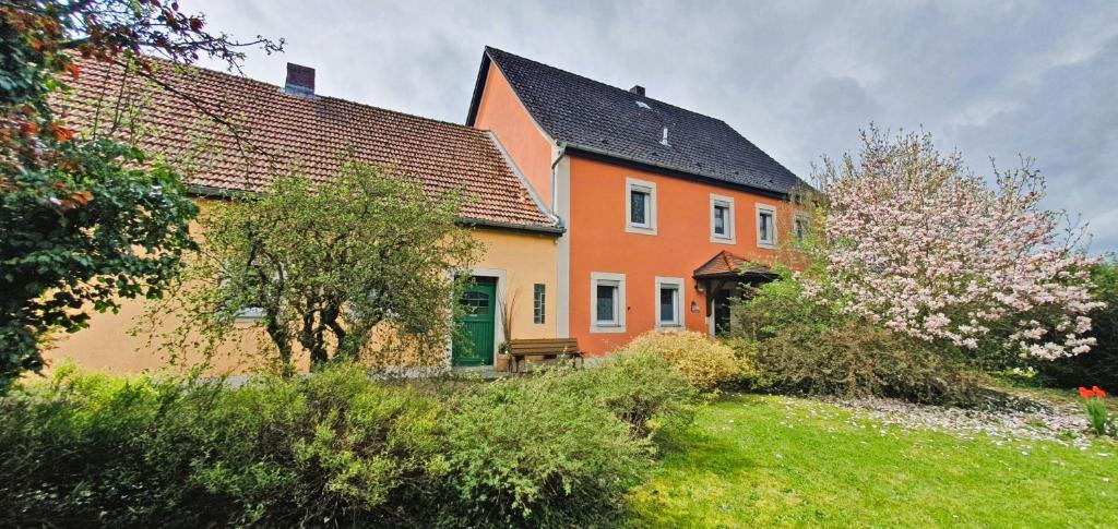 an orange house with a green door in a yard at Beim FörschtnSchorsch in Königsfeld