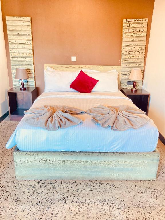 a bedroom with a large bed with a red pillow at Hotel 198 Negombo in Negombo