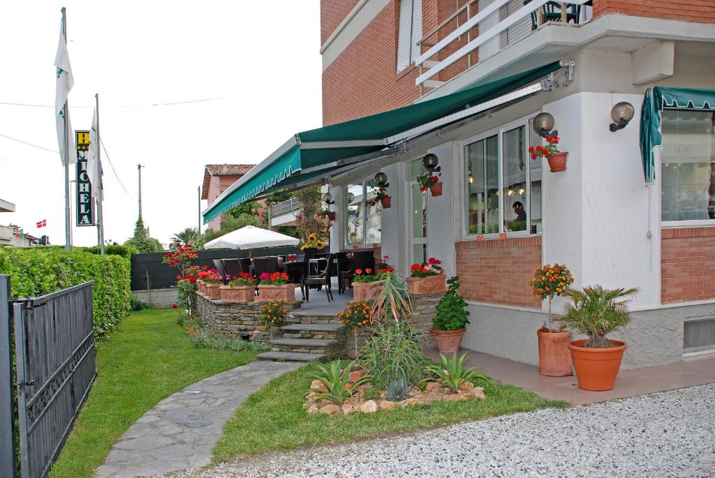 a restaurant with plants and flowers outside of a building at Hotel Michela in Marina di Massa