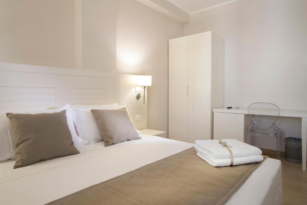 - une chambre blanche avec un grand lit blanc et des oreillers dans l'établissement Nesea Bed and Breakfast, à San Vito Lo Capo