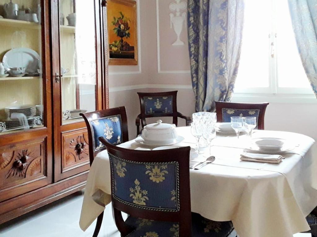 Un comedor con una mesa y sillas blancas. en Casa Alessandro Firenze, en Florencia