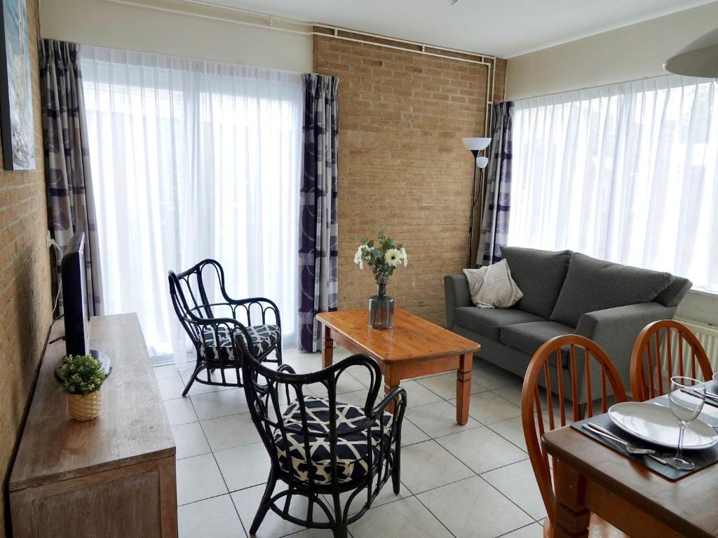 ein Wohnzimmer mit Sofa und Tisch in der Unterkunft Comfortable holiday home in Noordwijkerhout near the sea in Noordwijkerhout