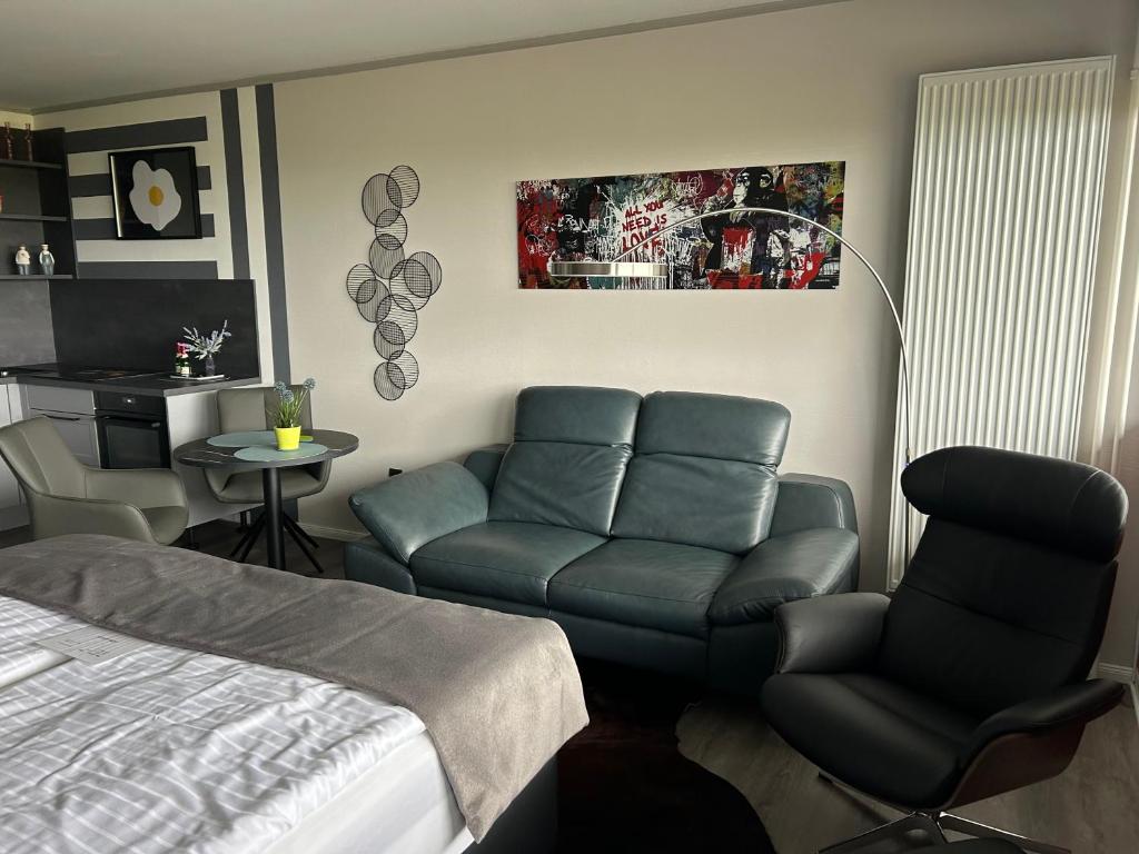 una camera da letto con un letto, un divano e una sedia di Studio Relax a Büsum