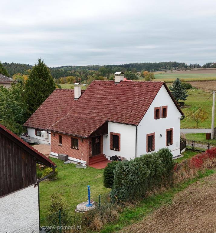 a large white house with a red roof at Chaloupka pod Rabštejnem in Hluboká