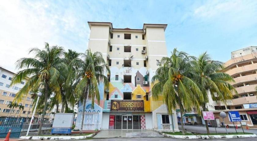 a large building with palm trees in front of it at OYO 90559 Ummul Motel C Mart in Arau