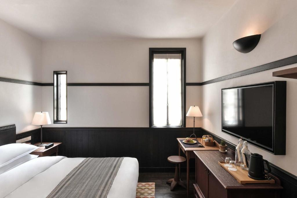 um quarto de hotel com uma cama, uma escrivaninha e uma televisão em Humble Hall em Gulang Yu