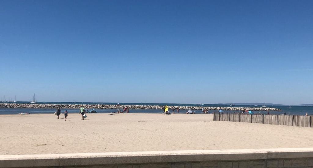 un groupe de personnes sur une plage près de l'océan dans l'établissement Grau du Roi Appartement proche de la mer, au Grau-du-Roi