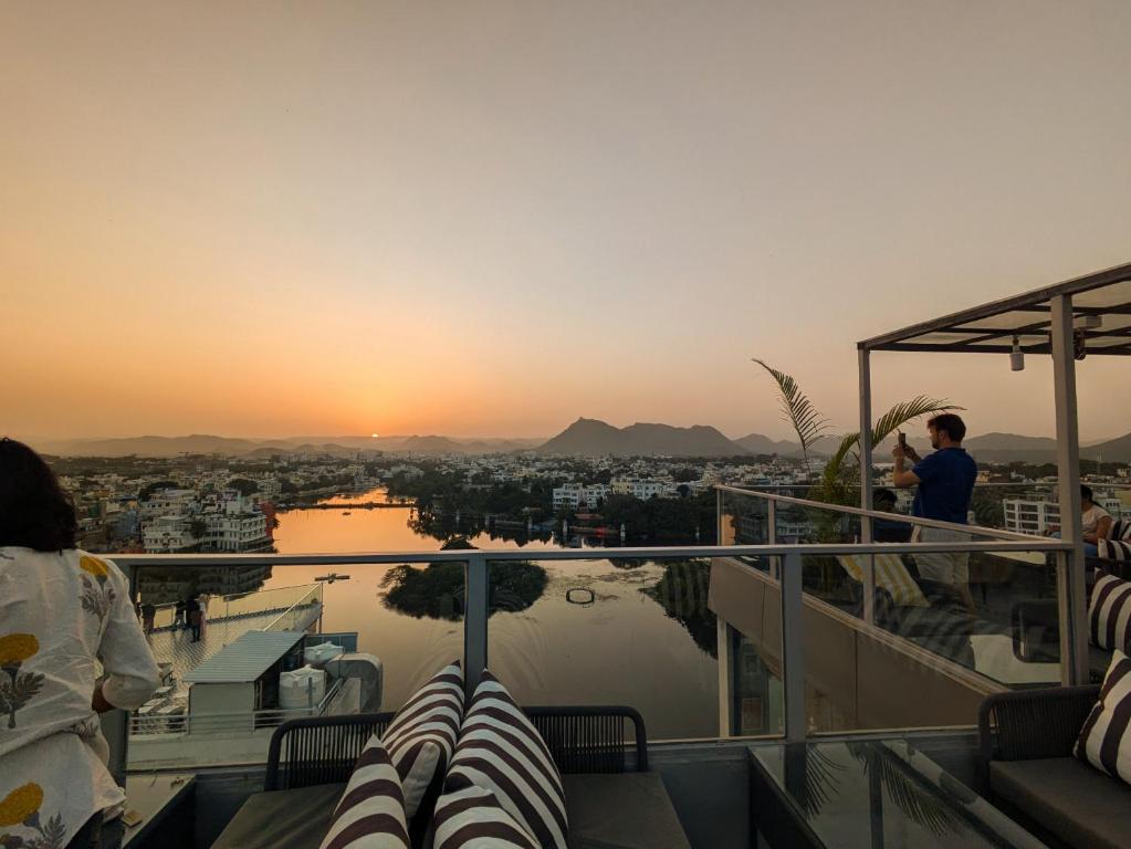 a man taking a picture of the sunset from a balcony at Bunkyard in Udaipur
