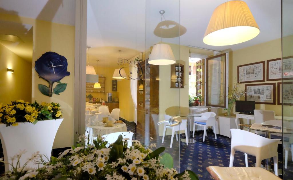 een restaurant met witte stoelen en een eetkamer bij My Hotel Milano in Milaan