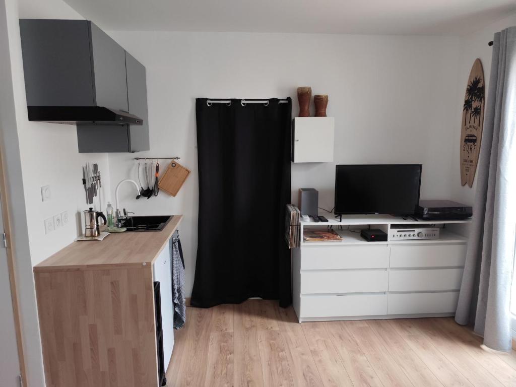 a kitchen with a black curtain in a room at Charmant studio indépendant en RDC chez Cyril et Stéph in Millas