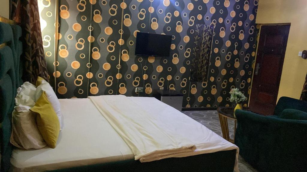 Un dormitorio con una cama y una pared con una cortina. en AY Hotel Reloaded, en Ikeja