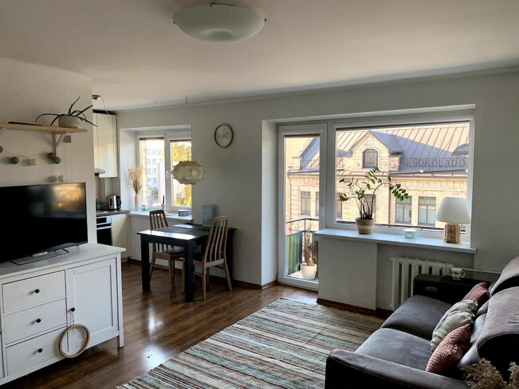 una sala de estar con un sofá y una mesa en Bright and cozy apartment in the city center with balcony, en Šiauliai