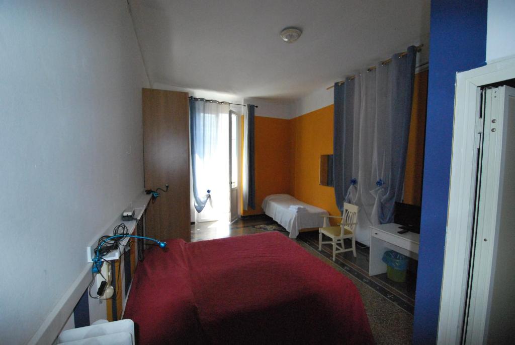ラパッロにあるAlbergo La Velaのベッドルーム1室(赤いベッド1台付)