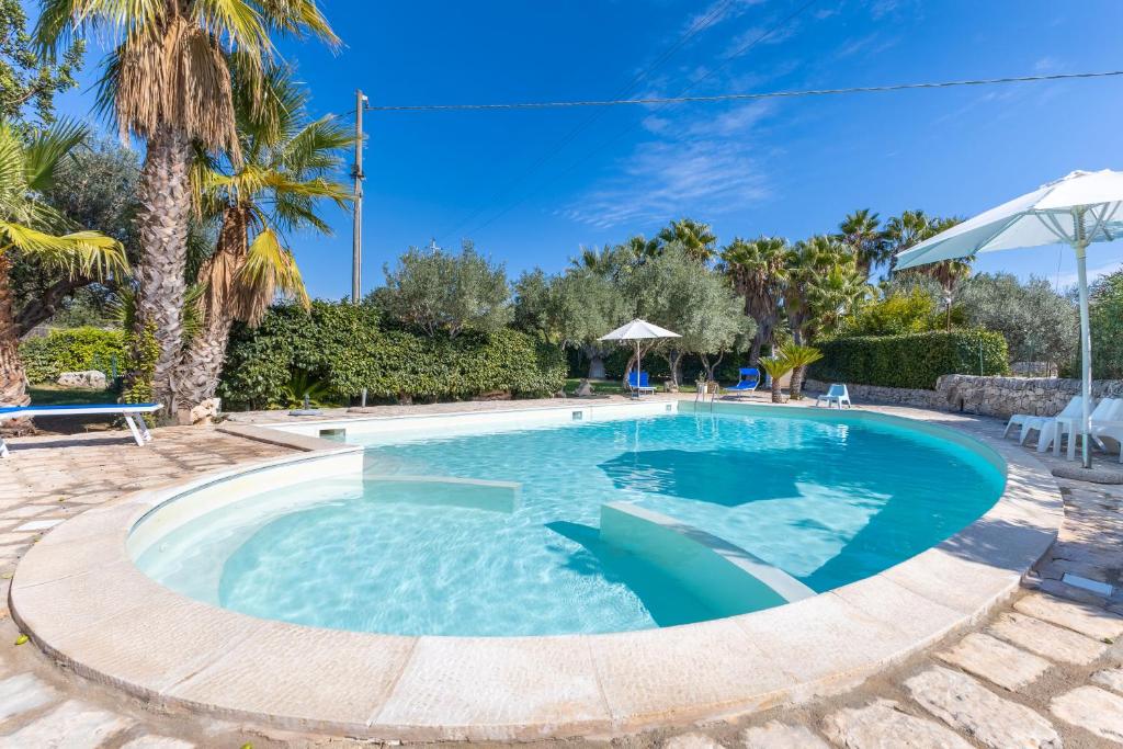 - une piscine dans un complexe avec des palmiers dans l'établissement Al Casale - private pool, à Raguse