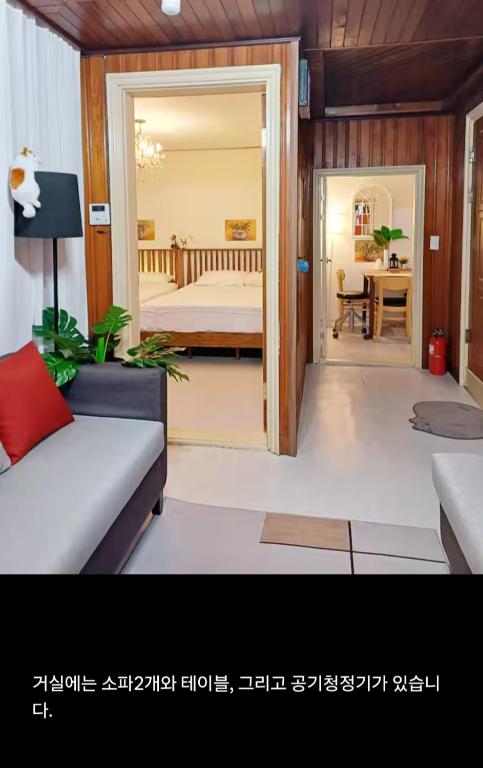 a living room with a couch and a bedroom at 어반 팀버 수원 in Hagwanggyo-dong