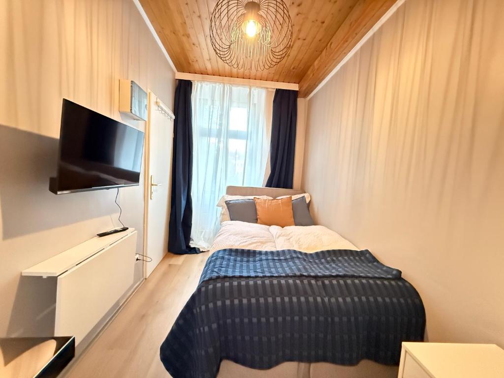 Un dormitorio pequeño con una cama y un televisor. en Near Mainstation I Urban Link I Free Wifi, en Viena
