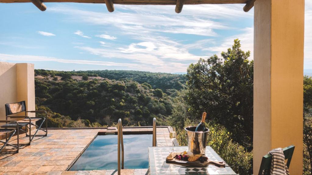 a patio with a table and a view of the mountains at Hitgeheim Garden Cottages in Addo