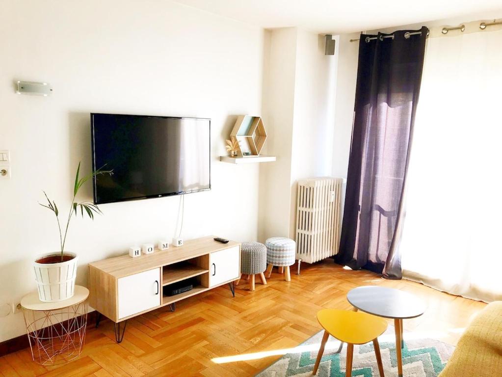 a living room with a flat screen tv on a wall at Bel appartement proche de toutes commodités in Grenoble
