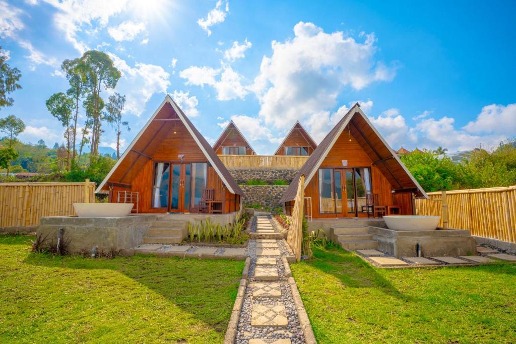 a home with a wooden house with a fence at Tirta Rahayu Camp in Kubupenlokan