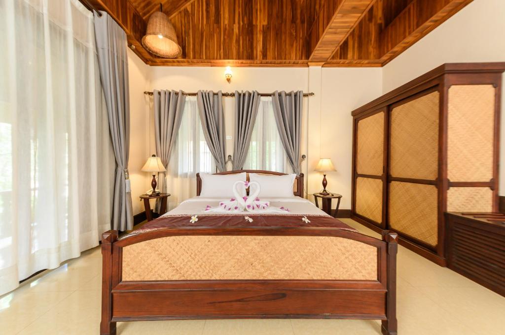 a bedroom with a large bed in a room at Treasure Heritage Hotel in Luang Prabang