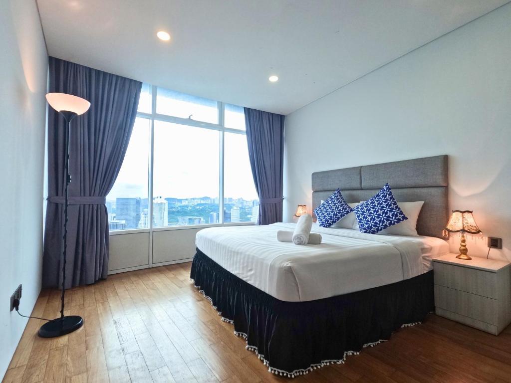 a bedroom with a large bed and a large window at Vortex Apartments Kuala Lumpur in Kuala Lumpur