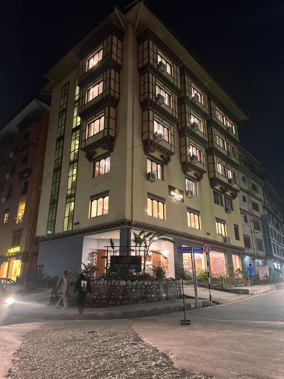 un gran edificio con ventanas iluminadas por la noche en DEWALING by Laughing Lama Hotels, en Phuntsholing