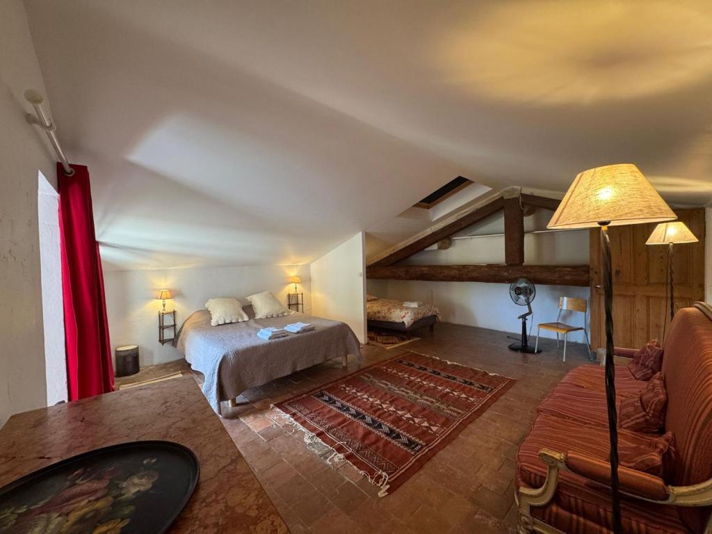 a bedroom with a bed and a living room at Maison du Berger - Vignoble Château Barbebelle, Rognes, maison provençale avec jardin partagé et parking - proche d'Aix-en-Provence - 5 personnes in Rognes