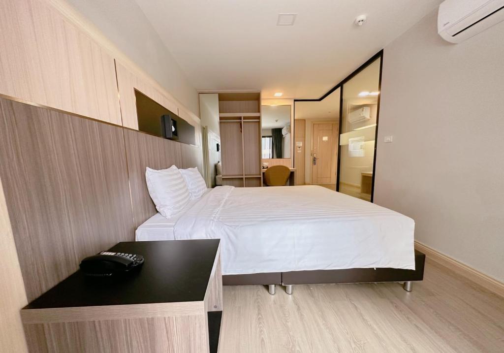 a bedroom with a white bed and a desk at โรงแรม โอทู แกรนด์ สุวรรณภูมิ แอร์พอร์ต in Bang Phli