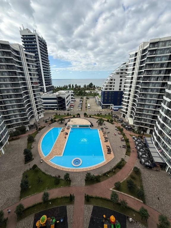 una vista aérea de una piscina en una ciudad con edificios altos en Rihlaa aprt c 1105, en Itʼkhvisi